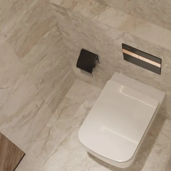 Contemporary Plumber Bathware wall-hung water closet with concealed flush plate in a marble-finished bathroom