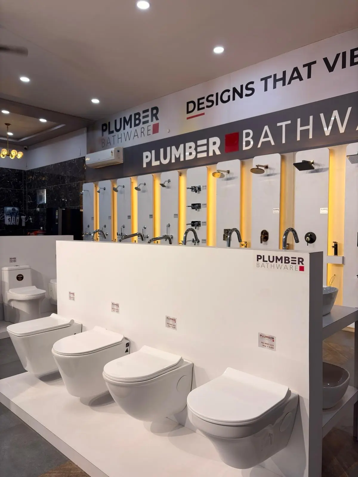 Plumber Bathware sanitaryware display featuring coordinated toilets and CP fittings